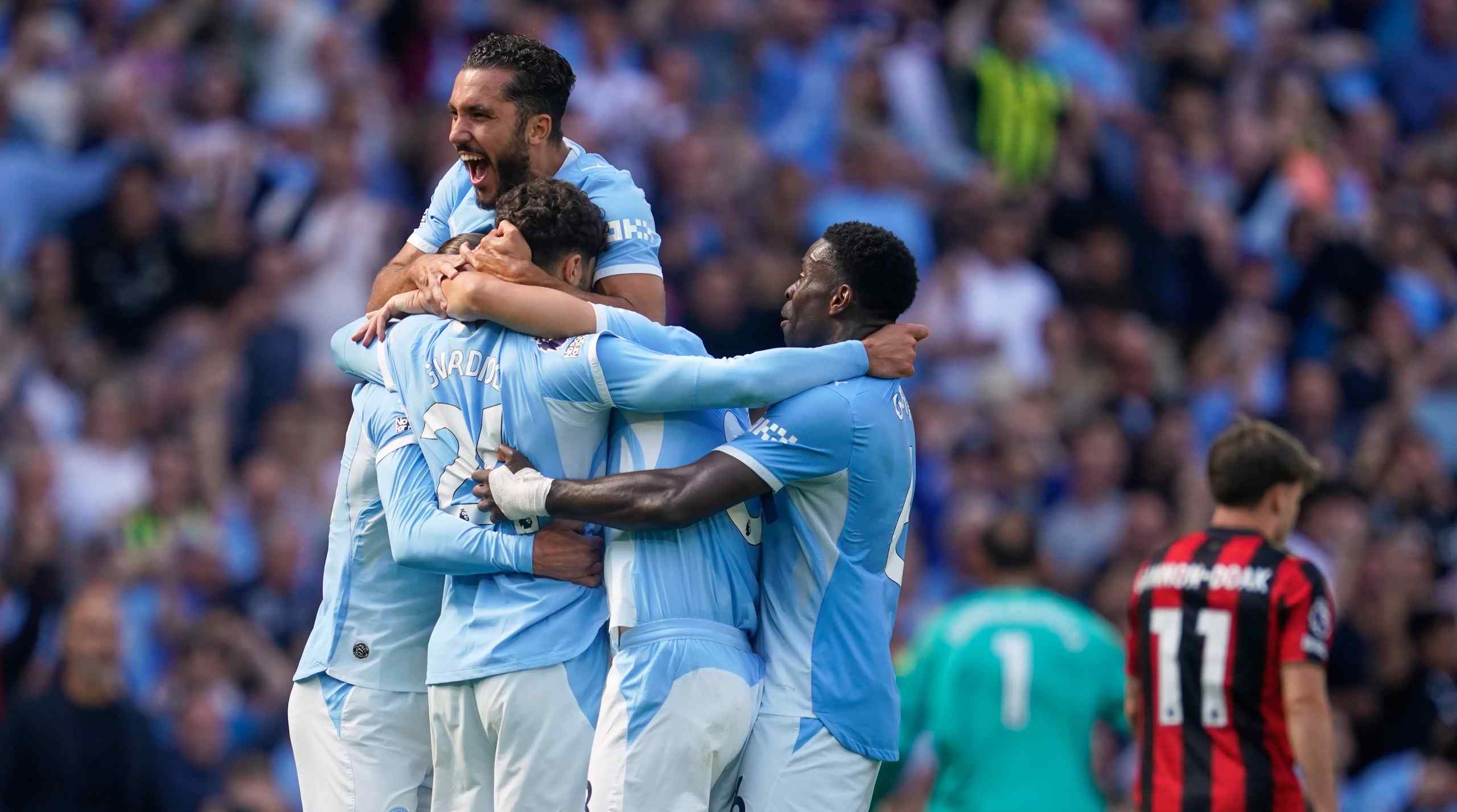 Man City players celebrating on the pitch.